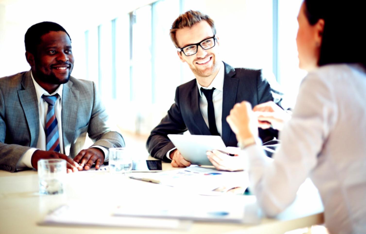 Students collaborating on web design projects with laptops and design materials